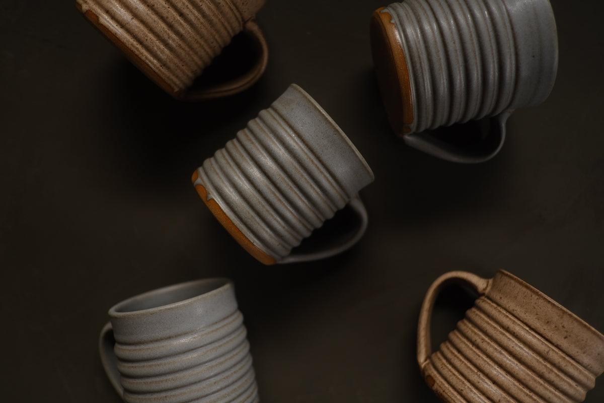 The Little Mug: top view of five ribbed ceramic espresso cups arranged on a dark surface.