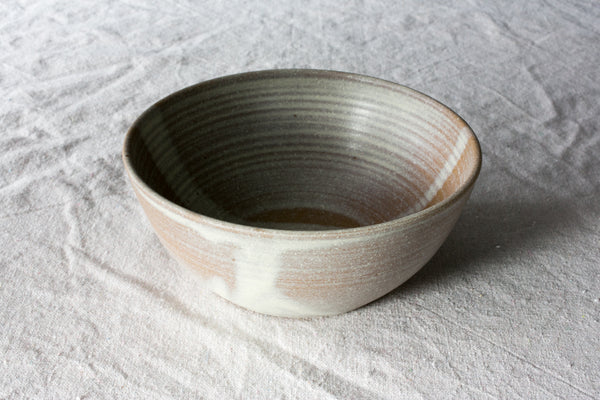 Wander Soup Bowl in two-tone dipped glaze with exposed throwing rings, resting on linen cloth.